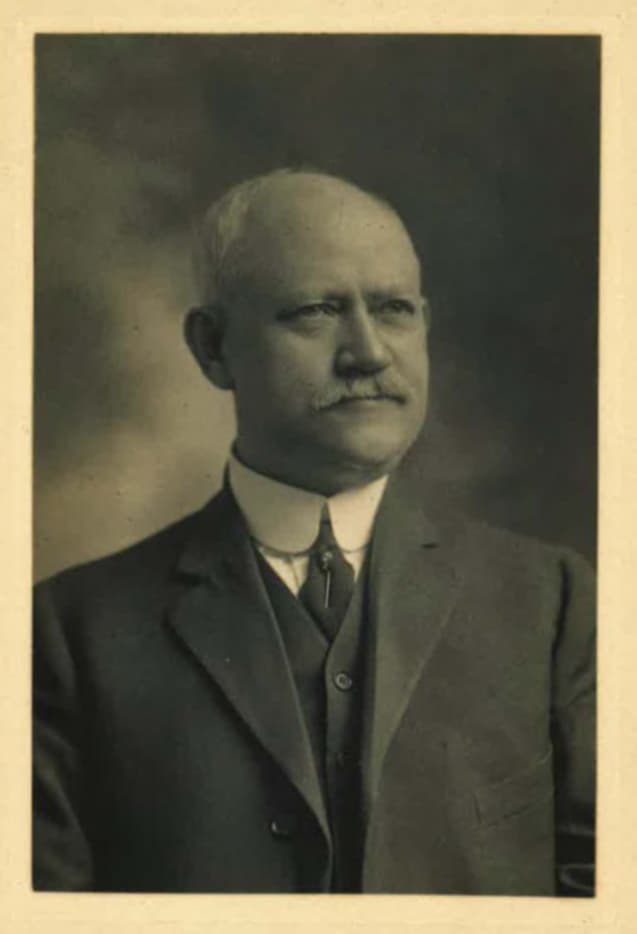 Sepia portrait photograph of Charles E. Reeb in a suit and high collar